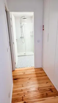 a bathroom with a shower and a wooden floor at Jardim do Morro Haus in Vila Nova de Gaia