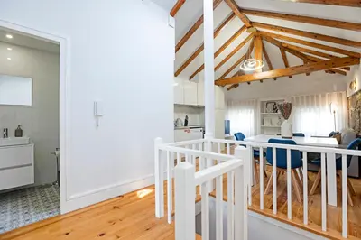 a kitchen and dining room with white walls and wooden ceilings at Modern Cativo Apartment by LovelyStay in Porto