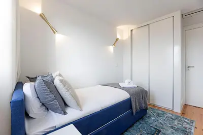 a bedroom with a blue bed with white pillows at Modern Cativo Apartment by LovelyStay in Porto