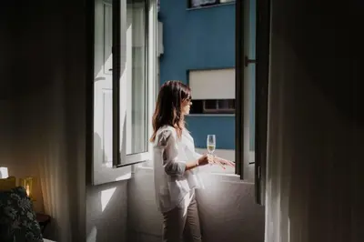a woman holding a glass of wine looking out the window at Bicycle Luxury House, parking, downtown near metro in Porto