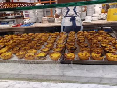 a bunch of donuts on trays in a bakery at Casa do Barqueiro - Porto in Porto