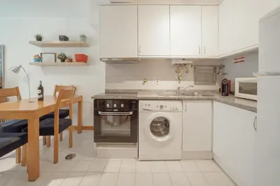 a kitchen with white cabinets and a washing machine at Downtown Trindade Apartment With Terrace by Vacationy in Porto