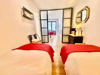 a room with two beds with red sheets and a mirror at Cristelo 0 - near the river Porto in Porto
