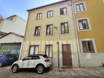 a white car parked in front of a yellow house at Cristelo 2 - near the river Porto in Porto