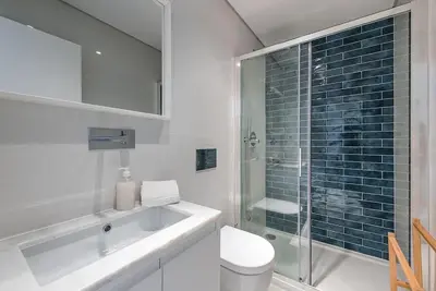 a bathroom with a toilet and a glass shower at Cedofeita Balcony with Free Parking in Porto