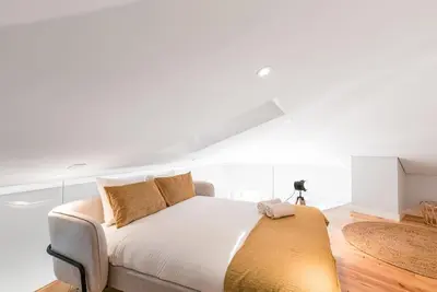 a white bedroom with a bed with a yellow blanket at Cedofeita Balcony with Free Parking in Porto