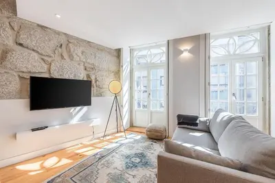 a living room with a couch and a tv at Cedofeita Balcony with Free Parking in Porto