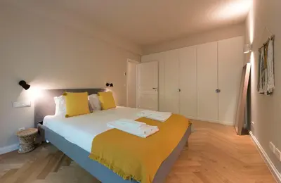 a bedroom with a large bed with yellow pillows at Luxury City Center Emporium in Porto