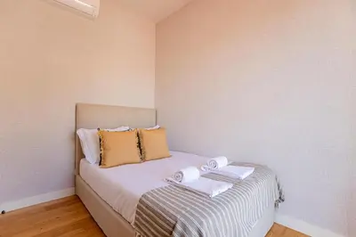 a small bedroom with a bed with towels on it at Wonderful Flat Near River w/ AC by LovelyStay in Porto