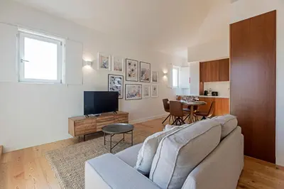 a living room with a couch and a tv and a table at Wonderful Flat Near River w/ AC by LovelyStay in Porto