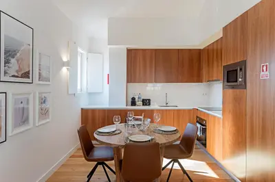 a kitchen with a table with wine glasses on it at Wonderful Flat Near River w/ AC by LovelyStay in Porto