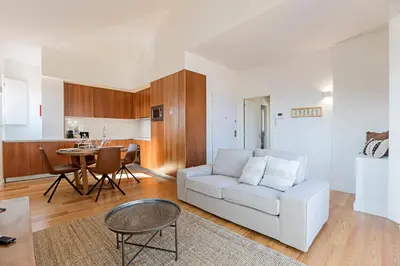 a living room with a white couch and a table at Wonderful Flat Near River w/ AC by LovelyStay in Porto
