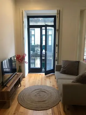 a living room with a couch and a television at Central charming apartment in Porto