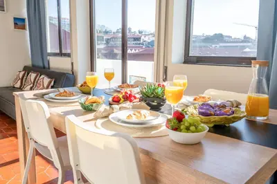 a dining room table with food and glasses of orange juice at Magnificent Sunny Flat - Douro River in Vila Nova de Gaia