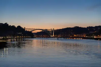 a view of a bridge over a river at dusk at Magnificent Sunny Flat - Douro River in Vila Nova de Gaia