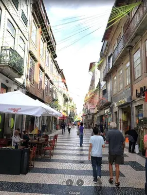a group of people walking down a city street at BREINER 28 in Porto