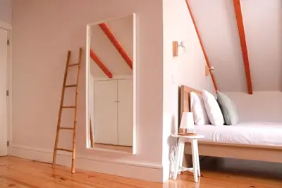 a bedroom with a bed and a ladder and a mirror at A Window to Porto - Fabulous apartment by Douro River in Porto
