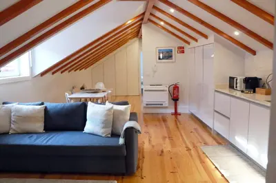 a living room with a blue couch and a kitchen at A Window to Porto - Fabulous apartment by Douro River in Porto