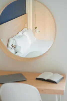 a mirror on a desk with a bed in a room at room Select Porto Suites in Porto