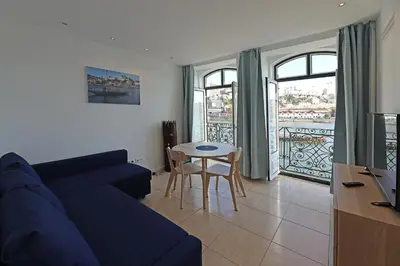 a living room with a blue couch and a table at FLH Porto Ribeira with River View in Porto