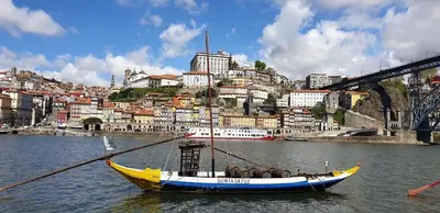 a boat in the water in front of a city at FLH Porto Ribeira with River View in Porto