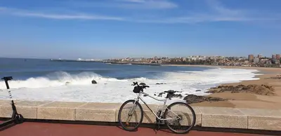 a bike parked on a wall next to a beach at FLH Porto Ribeira with River View in Porto