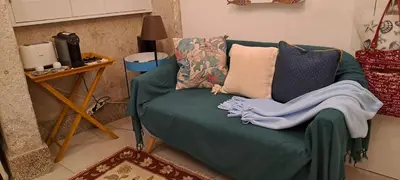 a living room with a green couch with pillows at FLH Porto Santa Catarina Cosy Flat in Porto