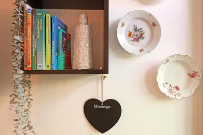 a book shelf with books and a heart on a wall at FLH Porto Santa Catarina Cosy Flat in Porto