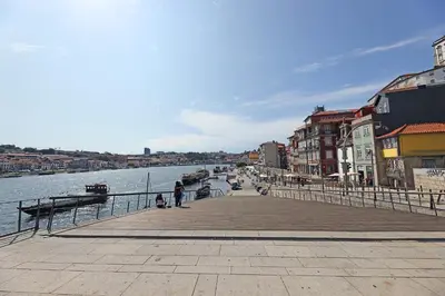 a woman standing on a pier next to the water at FLH Porto Classic Apartment with Terrace & Parking in Porto