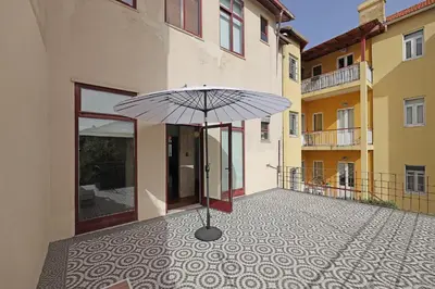 a umbrella sitting on a courtyard with a building at FLH Porto Classic Apartment with Terrace & Parking in Porto