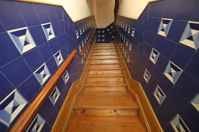 a hallway with blue tiled walls and wooden stairs at FLH Porto Classic Apartment with Parking in Porto