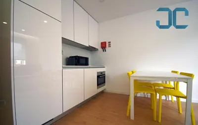 a white kitchen with yellow chairs and a table at Sogra Apartment by JC with Balcony in Porto