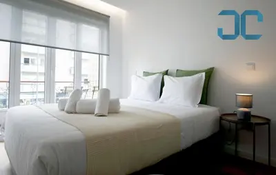 a bedroom with a large white bed with a large window at Sogra Apartment by JC with Balcony in Porto