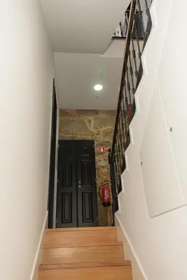 a hallway with stairs and a black door at Fervença Great Stay Apartment in Vila Nova de Gaia
