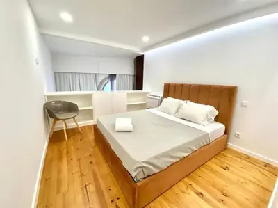 a bedroom with a bed and a chair in it at OHH-Padre Antonio Vieira Flat- HU in Porto