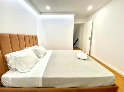 a bedroom with a bed with white sheets and pillows at OHH-Padre Antonio Vieira Flat- HU in Porto