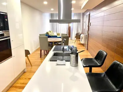 a kitchen with a counter with chairs and a table at OHH-Padre Antonio Vieira Flat- HU in Porto