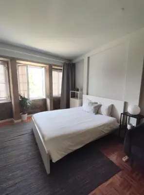 a bedroom with a large white bed and windows at Oporto Batalha Nice View Flat in Porto