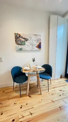 a dining room table with two chairs and a painting at Sol Garden in Porto