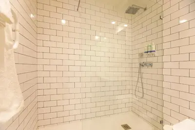 a white tiled bathroom with a tub and a shower at Loulé Luxury Garden W/ AC in Porto