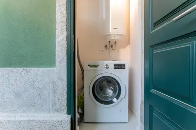a washing machine in a room with a door at Loulé Luxury Garden W/ AC in Porto