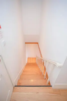 a staircase in an attic with white walls and wooden floors at Liiiving in Porto - Garden Light Mezzanine in Porto