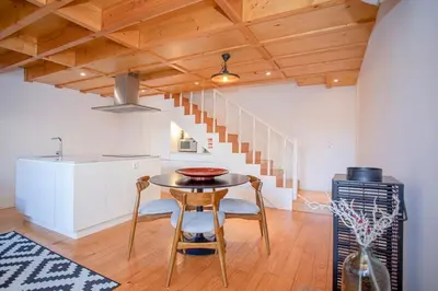 a kitchen and dining room with a table and a staircase at Liiiving in Porto - Garden Light Mezzanine in Porto