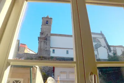 a window with a view of a clock tower at A Window to Porto - Premium apartment by the River in Porto