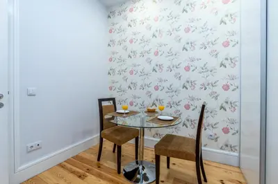a dining room with a table and chairs with a floral wallpaper at A Window to Porto - Premium apartment by the River in Porto