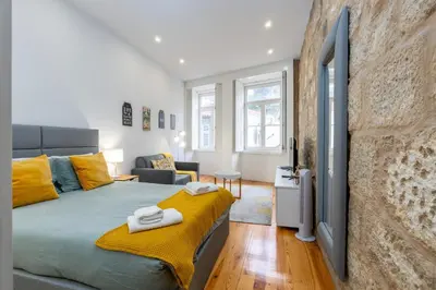 a bedroom with a large bed with yellow sheets at A Window to Porto - Premium apartment by the River in Porto