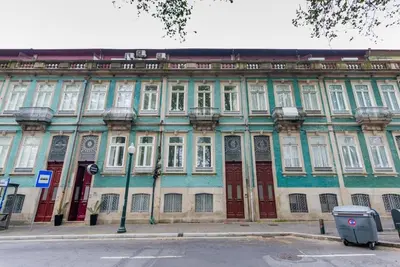 a large building with white windows and red doors at Classy Flat at Marques Square with Garden in Porto