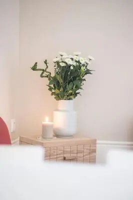 a table with a candle and a vase with flowers at Classy Flat at Marques Square with Garden in Porto