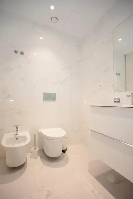 a white bathroom with a toilet and a sink at Liiiving in Porto - Dragão Pool View in Porto