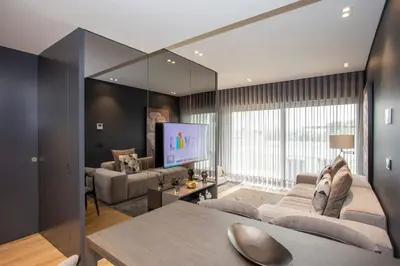 a living room with a couch and a tv at Liiiving in Porto - Dragão Pool View in Porto